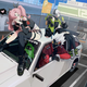Key art for Zenless Zone Zero featuring characters lounging on top of a car in a gas station parking lot.
